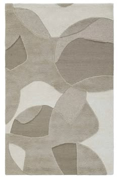 an area rug with various shapes and colors on the floor, including greys and white