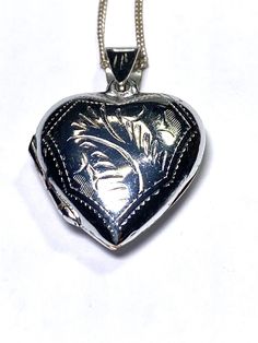 This is a sterling silver heart shaped picture locket. The locket is hinged and closes securely and tightly. The front and back are engraved with a leaf design.  The chain is sterling silver as well. . Vintage Heart-shaped Sterling Silver Locket Necklace, Antique Silver Heart Locket Jewelry, Antique Silver Locket Necklace For Valentine's Day, Silver Heart Locket Necklace For Valentine's Day, Valentine's Day Silver Heart Locket Necklace, Antique Silver Heart Locket Necklace, Silver Heart Pendant Locket Necklace With Heart Charm, Silver Heart Pendant Locket Necklace For Valentine's Day, Silver Locket For Valentine's Day