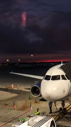 an airplane is parked on the tarmac at night