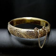 *Description: This is a beautiful Art Nouveau hinged silver bracelet with a gold wash from around the 1920s. It has European origins with stamps for silver and one difficult to read on the clasp. Photo is included. This silver bracelet with a gold wash was tested by me and tested for silver and minimum 10K gold wash or vermeil. The clasp and hinge are in great working order. If you are looking for a wonderful heirloom gift, this would be perfect. This bracelet would be a great addition to your v Antique Gold Bracelet Stamped 14k, Antique 14k Stamped Gold Bracelet, Vintage Yellow Gold Bangle Stamped 14k, Antique 14k Stamped Bangle As Gift, Elegant Antique Gold Bracelet Jewelry, Antique 14k Stamped Jewelry For Ceremonial Occasions, Antique Gold Brass Bracelets For Formal Occasions, Formal Antique Gold Brass Bracelets, Formal Antique Gold Brass Bracelet