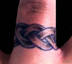 a close up of a person's hand with a tattoo on it that has an intertwined knot