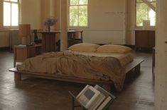 a bed sitting on top of a wooden floor in a bedroom