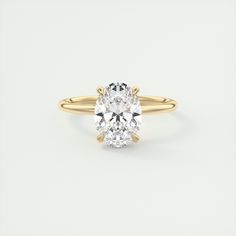 an oval cut diamond engagement ring in yellow gold with two clawed shans on the band