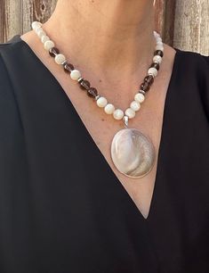 This stunning mother of pearl conch shell fossil pendant necklace is the perfect accessory for those who appreciate unique and one-of-a-kind jewelry pieces.  This necklace is not only a beautiful fashion statement, but also a historical piece of nature's artistry preserved through time.  Add this distinctive piece to your collection or gift it to a loved one who cherishes the beauty of nature's creations. Select your desired necklace length from the drop down menu. Please note as necklaces are m Unique Shell-shaped Mother Of Pearl Jewelry, Unique Mother Of Pearl Shell Jewelry, Handmade Mother Of Pearl Shell Necklaces, White Mother Of Pearl Pendant Shell Necklace, Unique Mother Of Pearl Shell Necklace Gift, Artisan Shell-shaped Mother Of Pearl Jewelry, Artisan Mother Of Pearl Shell Jewelry, Elegant Mother Of Pearl Shell Pendant Necklace, Unique White Shell Pendant Necklace