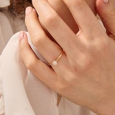 a close up of a person wearing a ring with a diamond on it's finger