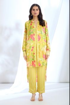 Yellow floral print tunic featuring collared neck, cuff sleeves and asymmetric hem. Paired with a stripe pattern pant. - Aza Fashions Spring Silk Kurta With Floral Print, Spring Silk Straight Kurta Tunic, Silk Tunic Straight Kurta For Spring, Spring Silk Tunic Straight Kurta, Floral Print Straight Kurta Blouse For Spring, Spring Floral Print Straight Kurta Blouse, Spring Tunic Sets With Printed Motifs, Spring Printed Tunic Sets, Spring Silk Tunic Set