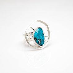 The Tranquility Turquoise Ring emits a peaceful and meditative quality. The American Turquoise focal point is known to be a "stone of the ancients." The ancients believed in the stone's power to protect. It also represents tranquility and good fortune among many spiritual attributes. A beautiful structural ring that entices meaningful conversation and contemplation. One-of-a-Kind Size 7. Unavailable for resize. Sterling Silver Rosecut American Turquoise To get your ring size, click here for our Spiritual Sterling Silver Turquoise Ring With Large Stone, Adjustable Chrysocolla Turquoise Ring, Turquoise Healing Ring With Large Stone, Modern Turquoise Round Ring, Spiritual Turquoise Ring With Natural Stones, Turquoise Chrysocolla Gemstone Ring, Spiritual Turquoise Ring For Healing, Spiritual Turquoise Healing Ring, Spiritual Healing Turquoise Ring