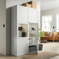 a living room with white furniture and an open cabinet