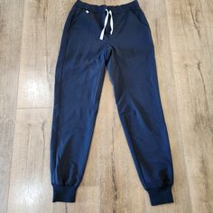 Featuring A Classic Nwt Figs Men's Tansen Black Jogger Pants In A Size Xs. Seamlessly Transition From Work To Workout To Play. The Fionx Tansen Has A Slim Fit, Five Pockets And Features Figs' 100% Awesome Proprietary Fionx Fabric. Total Of Five Pockets -Two Trouser Pockets -Two Back Welt Pockets -One Interior Security Pocket -Elastic Waistband With Adjustable Drawcord -Ribbed Ankle Cuffs -Engineered With Technical Comfort These Are In Excellent Nwt Condition. Add Them To Your Closet Today! Brand Navy Sporty Sweatpants With Elastic Waistband, Sporty Navy Sweatpants With Elastic Waistband, Navy Sporty Joggers For Loungewear, Sporty Navy Joggers For Loungewear, Casual Gray Yoga Pants For Gym, Sporty Navy Cotton Joggers, Navy Cotton Athleisure Joggers, Navy Cotton Sweatpants For Sports, Navy Functional Workout Bottoms