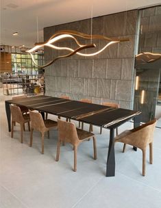 a dining room table and chairs in front of a wall with lights hanging from it