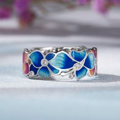 Blue flowers! How inspiring, unique, and elegant. This blue flower ring with silver details is intricately created, giving a realistic effect of the flower's beauty. At the same time, the subtlety and clarity of the enamel capture all the freshness and purity of the wildflowers. A romantic ring that has a flattering fit to a women's hand.Weight: 3.99 gMaterial: Plating Color: Blue Flower Ring For Anniversary, Elegant Blue Enamel Ring, Blue Flower Shaped Jewelry With Flower Decoration, Blue Flower-shaped Jewelry With Flower Decoration, Blue Floral Jewelry With Flower Decoration, Elegant Blue Flower Ring As Gift, Elegant Blue Adjustable Flower Ring, Elegant Adjustable Blue Flower Ring, Blue Floral Print Jewelry For Gift