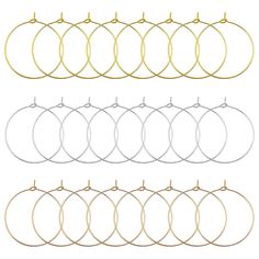 six pairs of gold, silver and black hoop earrings with hooks hanging from them on a white background