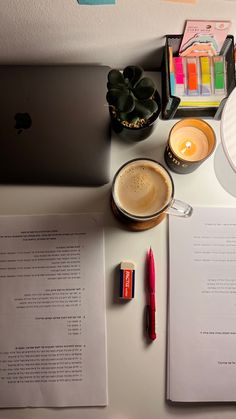 an open laptop computer sitting on top of a desk next to a cup of coffee