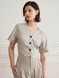 This is a modern and feminine shirt by yyiam that is made out of high quality and sturdy fabric. With unique design detail and trendy mood, you can style it for your clean and casual daily outfit.- Cropped silhouette with slim waist- Side welt pockets- Three button closure on the front- Raglan sleeves Modern V-neck Top For Spring, Casual Beige Office Top, Modern V-neck Blouse For Spring, Modern Button-up Blouse For The Office, Trendy Fitted Tops For Business Casual, Beige Office Lady Tops, Modern V-neck Workwear Blouse, Modern V-neck Blouse For Work, Elegant Structured Tops For Summer