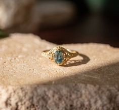 The dragonfly, a symbol of change, transformation, adaptability, and self-realization, embodies profound meanings rooted in mental and emotional maturity. This antique-style engagement ring, ideal for the alternative bride or daily wear, captures the essence of these concepts. It features a striking teal 1.17ct unheated sapphire accented by four antique diamonds, offering a timeless symbol of personal growth and enlightenment. 14kt yellow gold 1.17ct unheated blue green oval Montana sapphire center with visible inclusions, .04tcw of diamonds currently a size 7, can be sized up or down Heirloom Emerald Gemstone Ring For Promise, Ethereal 14k Gold Wedding Rings, Ethereal 14k Gold Wedding Jewelry, Adjustable 14k Gold Emerald Ring For Wedding, Yellow Gold Emerald Ring With Intricate Design, Heirloom Emerald Ring With Intricate Design, Ethereal Rose Cut Diamond Wedding Jewelry, Timeless Gemstone Wedding And Promise Ring, Vintage Emerald Ring For Promise