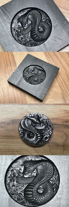 three metal plates sitting on top of a wooden table next to each other, one with an eagle and the other with a snake