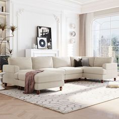 a living room filled with furniture and a large white rug on top of a hard wood floor