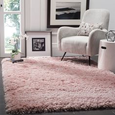 a living room with a chair and pink rug