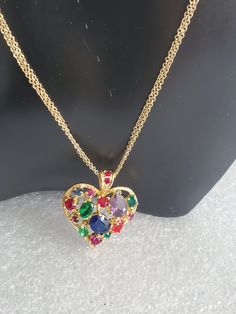 "If you are searching for the perfect Valentine's Day gift than you come to the right place. Presented here is a multi-colored glass heart pendant necklace that is strung onto a double curb chain. Both pieces are made in a gold tone base metal with no hallmark. The heart pendant has an open back where you can see the colored stones. The bale also has 2 small red stones and is big enough for any type of chain. Both pieces are vintage and are in excellent condition and will arrive in a gift box wi Multicolor Heart Charm Jewelry For Anniversary, Multicolor Heart Charm Necklace For Anniversary, Multicolor Jewelry Valentine's Day Gift, Multicolor Jewelry For Valentine's Day Gift, Valentine's Day Multicolor Jewelry Gift, Valentine's Day Gift Multicolor Jewelry, Multicolor Heart Necklace For Birthday, Multicolor Heart Charm Necklace For Party, Multicolor Pendant Necklace For Birthday