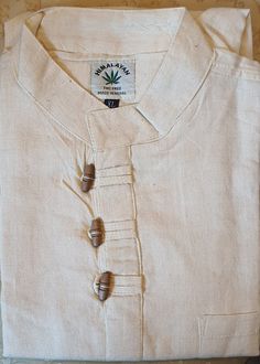 You are looking at full sleeve grandad Shirt/Kurta, with 3 hand carved wooden buttons  for casual, summer, festival,Yoga, beach use. Features:     ✔Colour: Cream/White    ✔Classic design    ✔Size Chart: Please look at 2nd picture    ✔Material:         1.Upto 40% Organic Hemp fibre         2.Upto 40% Sustainable Bamboo Fibre          3.Upto 20 % Cotton fibre    ✔3 Traditional handmade wooden buttons fitted    ✔High quality fabric    ✔High quality stitching 1.Hemp Fibre: Hemp fibre is sustainable fibre obtained from hemp plants mostly found in empty or barren lands in Asian countries.Normally, it grows without needing any care, water or pesticides. It helps to lower carbon footprints and also does not cause any damage to soil quality. 2.Bamboo Fibre: Speciality of Bamboo Fibre: ✔Very very so Traditional Long Sleeve Shirt With Button Closure, Casual Cotton Kurta With Button Closure, Traditional Stand Collar Top With Buttons, Casual Long Sleeve Beige Kurta, Casual Beige Long Sleeve Kurta, Beige Long Sleeve Casual Kurta, Traditional Cotton Top With Stand Collar, Cotton Festival Tops With Buttons, Festival Cotton Tops With Buttons