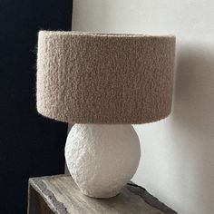 a large white ball sitting on top of a wooden table next to a lamp shade