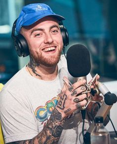 a man with headphones on sitting in front of a microphone