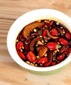 a white bowl filled with food on top of a wooden table