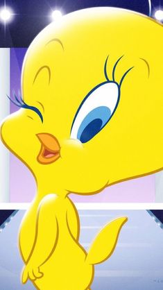 a yellow bird with big blue eyes sitting on top of a table in front of a mirror