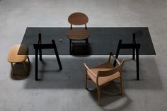 a table with chairs and a chair on it in the middle of an empty room