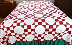 a red and white quilt on a bed