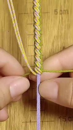 two hands are working on a piece of string