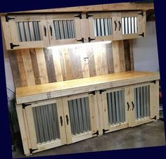 a large wooden cabinet with glass doors and bars on the top, in a garage