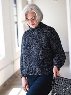 an older woman is holding a basket and looking down at the floor while wearing glasses