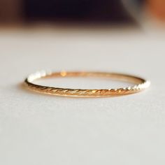 This Skinny Sparkle Ring is crafted from 14K yellow gold filled, giving it an attractive and durable dainty sparkle. The ring is diamond cut, which gives it an added sparkle that makes this piece of jewelry shine. Dainty 14k Gold Midi Rings With Diamond Cut, Dainty Midi Rings For Promise With Diamond Cut, Minimalist Gold Plated Diamond Cut Rings, Minimalist Diamond Cut Gold Plated Rings, Dainty Yellow Gold Crystal Ring With Round Band, Gold Dainty Crystal Ring With Simple Design, Dainty Gold-plated Rings With Diamond Cut, Dainty Gold Plated Rings With Diamond Cut, Gold Crystal Ring With Diamond Cut In 14k Gold