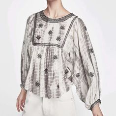 From Zara Comes This Embroidered And Embellished Boho Style Gray And White Tie Dye Blouse In Sz Small. In A Peasant Style Silhouette With 3/4 Balloon Sleeves, Dolman Style, Slightly Cropped Detail, Black Beading And Embroidered Detail Along Neckline And Yoke As Well As Sleeve Hems, Geometric Stitched Embroidery Throughout, Back Button Closure. Crew Neck. Measurements Bust Flat Approximately 23” Length 22”. Long Sleeve Blouse With Pearl Embroidery, Embroidered Puff Sleeve Tops For Fall, White Embellished Cotton Tops, White Puff Sleeve Tops With Embroidered Sleeves, Zara Blouse With Floral Embroidery For Fall, Embroidered Cotton Tops With Lantern Sleeves, Chic Summer Tops With Embroidered Sleeves, White Puff Sleeve Embroidered Top For Summer, Chic Summer Top With Embroidered Sleeves