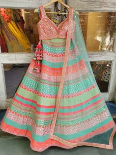 This multicolored banarsi, chanderi silk mixed panelled lehenga is paired with a rainbow mirror work choli.  The outfit is completed with a mint net mukaish dupatta.
NOTE: Ready-to-Ship in a size Medium. Ships in 3 days. Multicolor Chanderi Anarkali Set For Reception, Green Chanderi Lehenga With Cutdana, Designer Multicolor Anarkali Set With Zari Work, Multicolor Anarkali Set With Gota Work, Multicolor Raw Silk Anarkali Set, Anarkali Style Multicolor Sharara With Cutdana, Multicolor Chanderi Sharara For Reception, Multicolor Semi-stitched Anarkali Set For Designer Wear, Designer Multicolor Bohemian Sharara