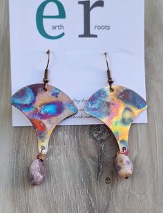 These boho shaped earrings feature fan shaped copper blanks that have been fire painted using a propane torch to bring out the different colors in the metal when heated.   NOTE:  Certain lighting will make the colors pop more than other types of lighting. They are finished with lepidolite gemstone bead dangles. These earrings will ship in a gift box via USPS with tracking info provided. Nickel-free Copper Artsy Jewelry, Artsy Nickel-free Copper Jewelry, Artsy Copper Drop Earrings, Unique Hand Painted Copper Jewelry, Unique Hand-painted Copper Jewelry, Bohemian Hand Painted Copper Jewelry, Bohemian Hand-painted Copper Jewelry, Hand Painted Copper Artsy Earrings, Artsy Hand Forged Copper Jewelry