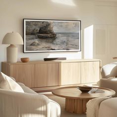 a living room filled with furniture and a painting hanging on the wall over a coffee table