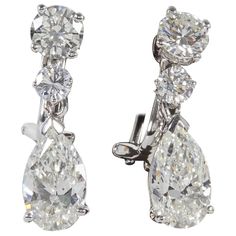 A beautiful pair of classic diamond dangle drop earrings set in a timeless design. 3.00 cts (total) of pear shapes suspended from 1.30 carats (total) of round brilliant cut diamonds. The diamonds are near colorless white, H/I VS1-SI1. The pear shape drops are certified by GIA. Set in 14k white gold. Approximately 2 cm in length. Made by Diamond Scene in New York Heart Shaped Diamond Earrings, Pear Shapes, Iconic Jewelry, Argyle Pink Diamonds, Earrings Hanging, Diamond Shape Earrings, Swirl Earrings, Diamond Dangle Earrings, Heart Shaped Diamond