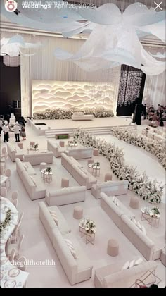 a room filled with lots of white couches and tables