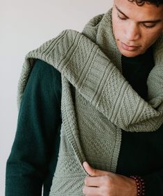 a man wearing a green sweater and scarf