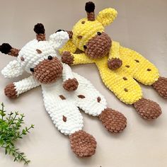 three crocheted giraffes laying next to each other on a table