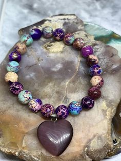 This beautiful galaxy sea sediment Jasper amethyst heart stretch bracelet is so full of vibrant colors!  It's made with 8 mm Galaxy sea sediment Jasper natural, round beads with a beautiful amethyst heart focal dangle. It's a stunningly gorgeous bracelet full of wonderful colors!    7 inches in length on 100% polyester stretch cord, not wire. Spiritual Heart Beads Bracelet Gift, Bohemian Purple Bracelets With Heart Beads, Spiritual Heart-shaped Beaded Bracelets For Valentine's Day, Hand-strung Heart Shaped Jewelry Gift, Hand-strung Heart Shaped Jewelry For Gift, Hand-strung Heart Jewelry As Gift, Hand-strung Heart Jewelry For Gift, Heart Shaped Beaded Bracelet With Gemstone Beads For Gift, Heart-shaped Beaded Bracelet With Gemstone Beads For Gift