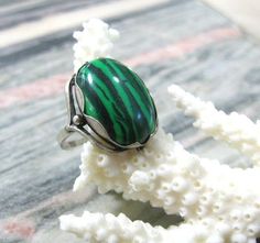 Vintage fashion jewelry, Malachite imitation woman's ring in size 9.Only 1 item available, not adjustable and not resizeable. Very good condition.Size: 9 ( US and Canada ), R 3/4 ( UK and Australia ), 19 ( Europe ).Stone: stripy green MAlachite imitation ( AKA pressed stone or reconstituted malachite )The stone is oval shape, measuring 14X10 mm and standing 7 mm tall over the finger surface.Material: Silver plated brass.This is a high quality ring in electric silver plate with 980 silver that la Adjustable Fit Emerald Ring, Green Turquoise Cabochon Ring, Unique Green Emerald Ring For Formal Occasions, Vintage Green Turquoise Ring, Green Emerald Cabochon Rings, Formal Green Turquoise Gemstone Ring, Adjustable Turquoise Gemstone Ring, Green Cabochon Ring Jewelry, Adjustable Green Turquoise Gemstone Ring