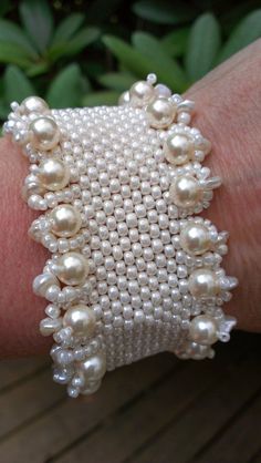 a white beaded bracelet on someone's arm