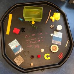 a black tray topped with lots of different types of items and writing on top of it