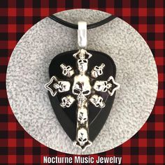 For the love of Goth! 💀 For women and men  Large silver Cross of Skulls Charm on black celluloid and black delrin picks.  Large silver bail.  Solid and sturdy pendant.  Length approx 2 inches.  Style choice:  Stainless Steel Chain 24" Stainless Steel Chain 20" Black leather cord 18" (w/2" ext) Silver Halloween Concert Jewelry, Black Jewelry For Halloween Concert, Silver Jewelry For Halloween Concert, Handmade Black Jewelry For Concert, Handmade Black Jewelry For Concerts, Black Rock Style Jewelry For Halloween, Black Engraved Necklace For Halloween, Black Engraved Jewelry For Halloween, Engraved Black Jewelry For Halloween