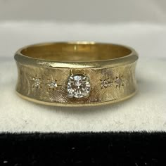 a yellow gold wedding ring with diamonds on it