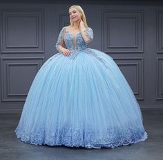 a woman in a blue ball gown posing for the camera