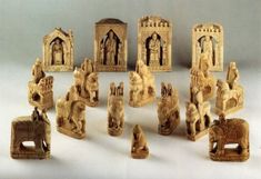 a group of carved wooden figurines sitting on top of a white table next to each other